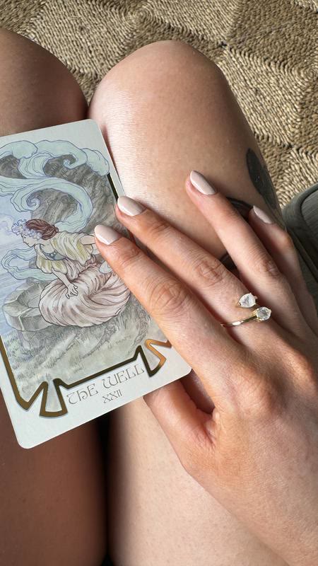 A hand resting on a single tarot card