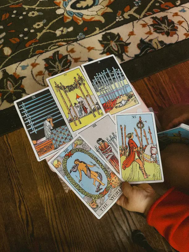 A three-card tarot spread on a patterned rug